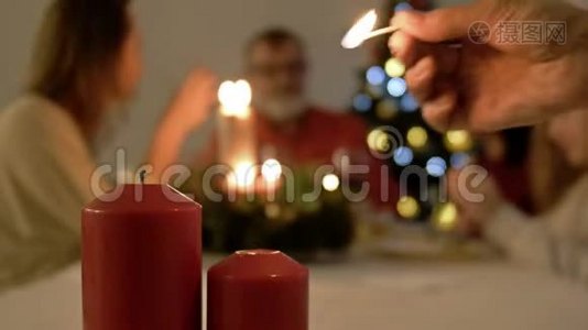 妇女点燃餐桌上的蜡烛，用于圣诞节或新年晚餐。 餐桌和大家庭背景视频