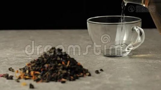 茶道。 绿茶被倒入一个透明的杯子里，放在靠近绿茶堆的黑色背景的桌子上视频