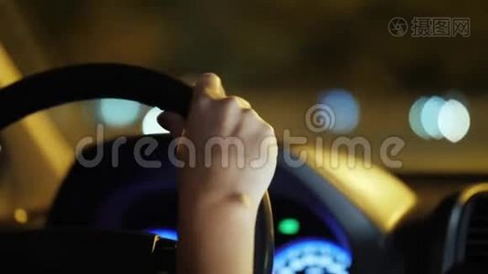 女性的手在汽车的车轮上。 开车穿过夜城视频