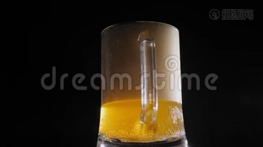 一杯带有泡沫的淡啤酒慢慢地在黑色背景上旋转。 特写镜头。视频