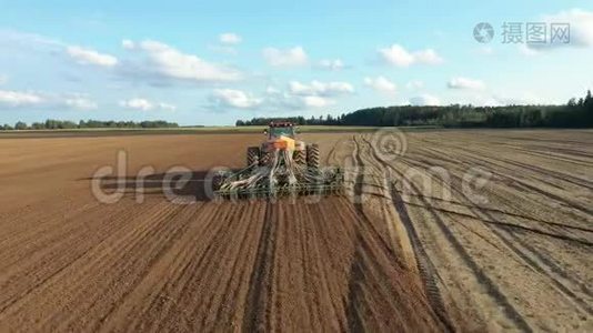 农民在拖拉机上播种农田土壤中的种子视频