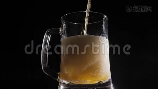 在一个啤酒杯里倒入了一杯啤酒，慢慢地打开黑色的背景。视频