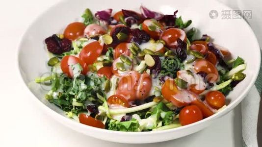 蔬菜沙拉的绿叶混合，西红柿，南瓜子，干蔓越莓和调料视频