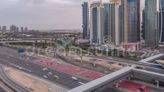 从空中俯瞰到迪拜码头附近的谢赫扎耶德路和JLT，白天到晚上，迪拜。视频