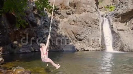 少女少年从蹦极跳入山河流淌的瀑布景观.. 少女潜入瀑布视频