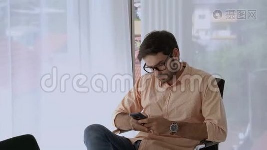 那个英俊的白人坐着用手机，态度轻松视频