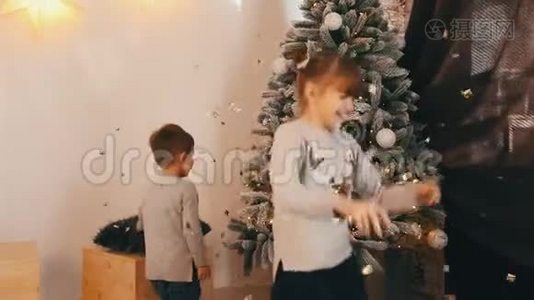 两个快乐的孩子在玩，旋转和嘲笑圣诞树视频