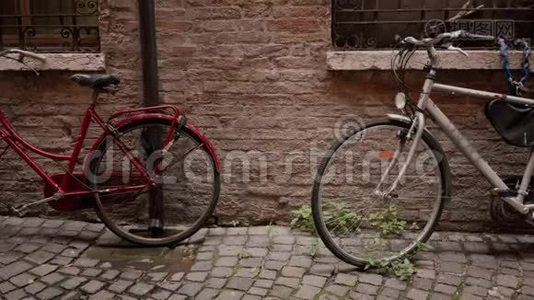 两辆旧的经典自行车红白相间停在古老的砖墙附近视频