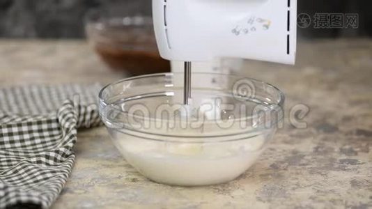 年轻的家庭主妇混合鲜奶油。视频