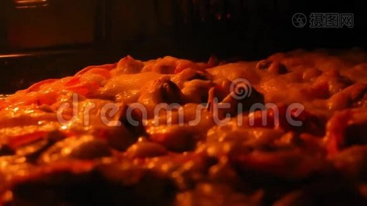 披萨是在烤箱里烤的。 奶酪上冒出气泡。 透过彩色玻璃的景色。视频