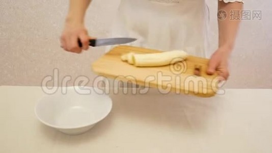 女孩把切好的香蕉放进盘子里。视频