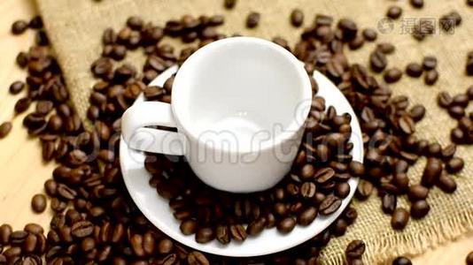 把一杯土耳其咖啡倒入一个白色的杯子里。 麻布和木头背景。视频