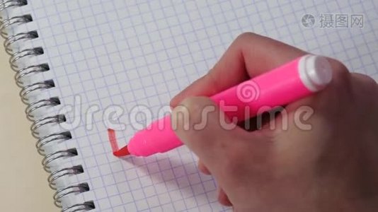 一个女人的手在记事本上用粉红色的记号笔写着“我爱你”这个词。视频