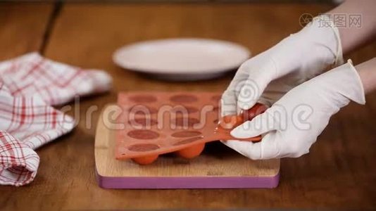 女性手拿草莓果冻从一个灵活的硅胶模具，特写。视频