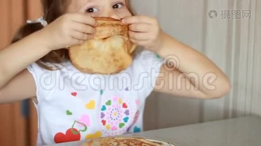 小女孩吃煎饼。 孩子笑着玩煎饼视频