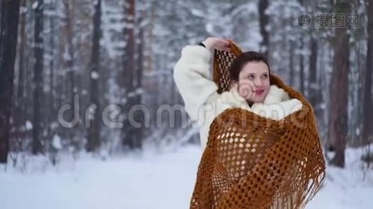 穿着冬衣的女人在雪林中温暖的冬天里欢乐。视频