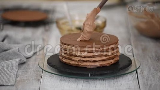 一步一步。 糕点厨师制作巧克力层蛋糕与修剪填充。 糖果师把奶油放在蛋糕上。视频
