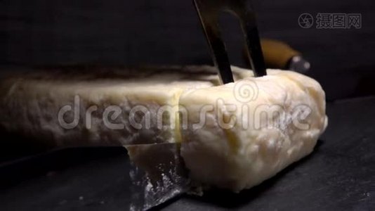 叉子从一块黑石板上举起一块柔软的山羊奶酪视频