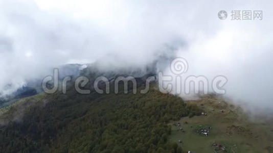 空中飞行在高山上的森林上空，穿过云层视频