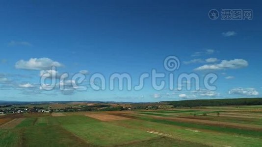空中无人机在美丽的乡村和蓝天白云中看到大的耕地。视频