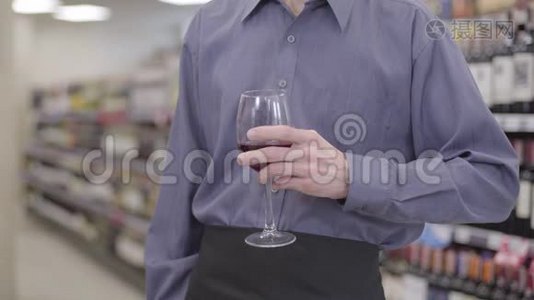无法辨认的白种人把酒杯伸到镜头前。 男性手拿酒杯，红酒夹在中间视频