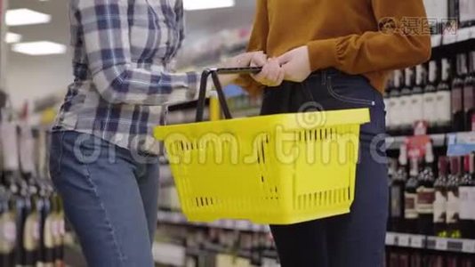 两个面目全非的白种人妇女站在超市里的酒架之间，放着一瓶红色和视频