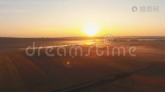 空中景观电影无人机镜头在日落时间。 在乌克兰的一条河的上空飞行，在黄昏的薄雾中有田野。视频