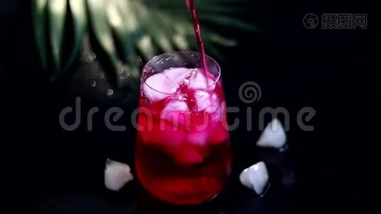 覆盆子-巴宝莉饮料在透明玻璃与冰。 饮料倒入玻璃杯中.. 添加棕榈枝和覆盆子。视频