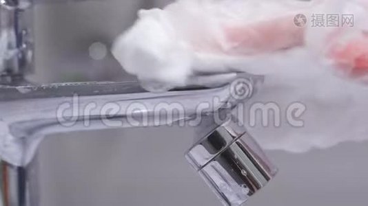 一个女人用洗涤剂和消毒剂洗手浴室里的水龙头`特写镜头，防止了视频
