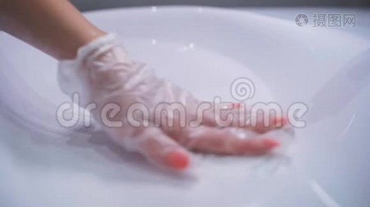 女人戴着手套`手洗白色浴室洗手池，每天消毒公共区域，以防止扩散视频