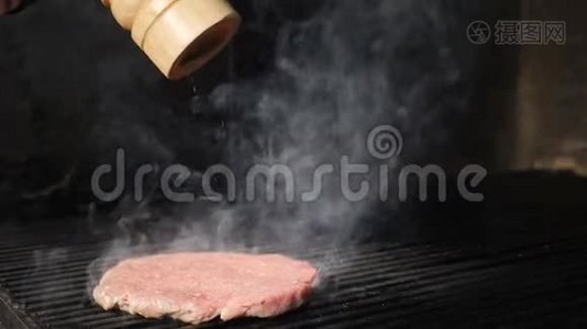 慢动作食物视频.. 汉堡包烹饪。 在烤炉上放上新鲜的汉堡馅饼，因为胡椒粉被洒在上面视频