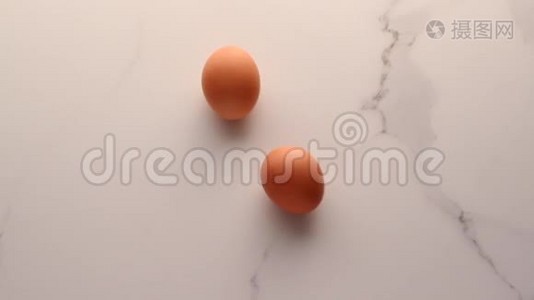 大理石桌上的鸡蛋作为最低限度的食物平躺，顶部看食品品牌的视频平躺和烹饪的食谱视频