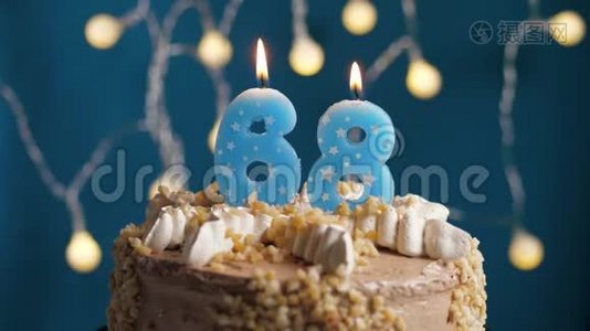 生日蛋糕，蓝色背景上有68个数字蜡烛。 蜡烛吹灭了。 慢动作和特写视频