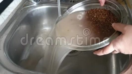 荞麦是生的。 在一股浓密的水流下洗涤，以便下一步准备..视频