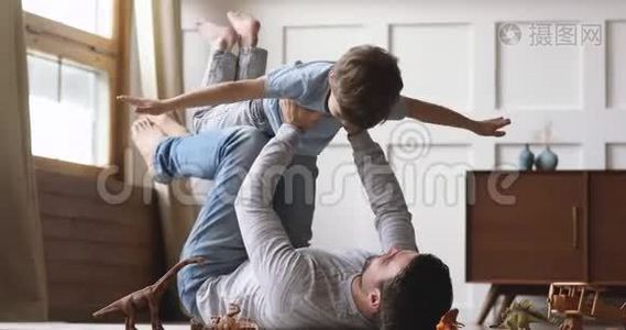 无忧无虑的爸爸举起小儿子假装超级英雄在一起视频