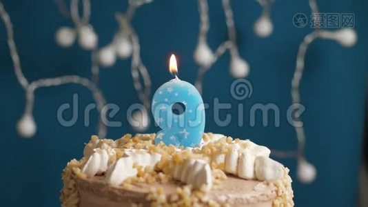 生日蛋糕，蓝色背景上有9个数字蜡烛。 蜡烛吹灭了。 慢动作和特写视频