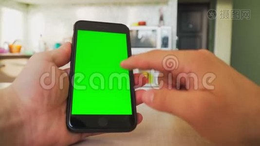 男人手里拿着智能手机，手里拿着绿色屏幕，手里拿着带有色度键的手机。视频