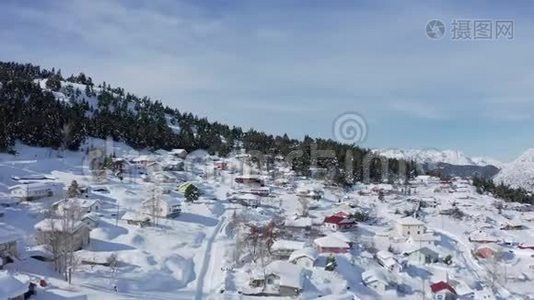 4K空中视频，一个村庄和森林在山上覆盖着雪。 土耳其的金牛山。视频