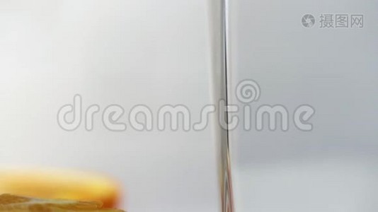 鲜榨的橙汁倒在桌子上的玻璃杯里，旁边放着几片橘子。 新鲜黄色饮料视频