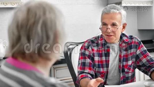 热情的老年男性在厨房与成熟的妻子交谈，有积极的情绪视频