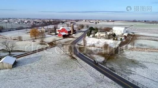 美丽乡村的空中景色，以及一匹马和一匹马在经过一场轻雪后沿着这条路行进视频