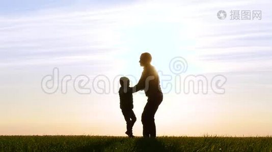 日落时分幸福家庭的剪影。 一个父亲牵着儿子`手和旋转，玩和玩。视频