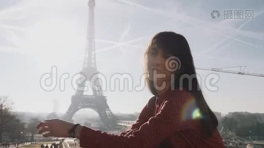 美丽快乐的白种人黑发女人在巴黎埃菲尔铁塔摆姿势的肖像，阳光明媚的风景慢动作视频