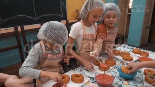 孩子们在烹饪学校准备烹饪大师班的甜甜圈。 孩子们一起在面包学校做甜甜圈视频