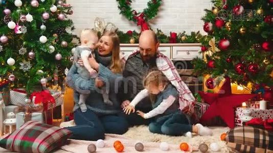 新的一年-爸爸妈妈和孩子们坐在毯子下笑着接吻视频