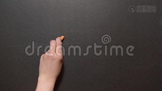 目标。一只左手在黑板上用橙色粉笔写下“目标”一词。概念粉笔画视频