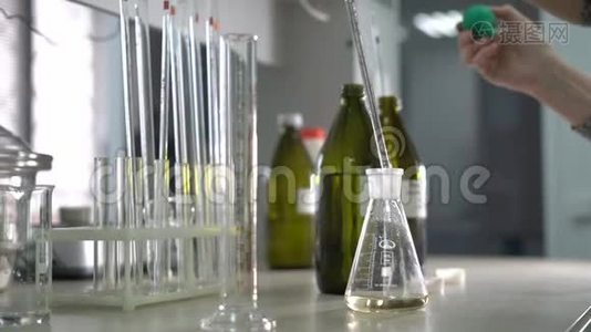 工厂分析实验室。 一名女性实验室助理将液体混合在玻璃瓶中。 特写镜头。视频