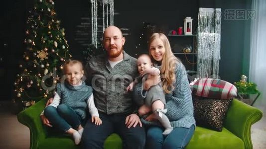 圣诞节概念-幸福的家庭坐在沙发上摆姿势拍照视频
