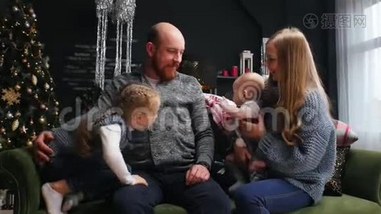 新年-爸爸在沙发上抱着他的孩子和妻子视频