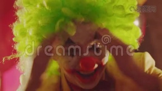 一个疯狂的微笑小丑用双手闭上脸，表现出令人毛骨悚然的情绪视频